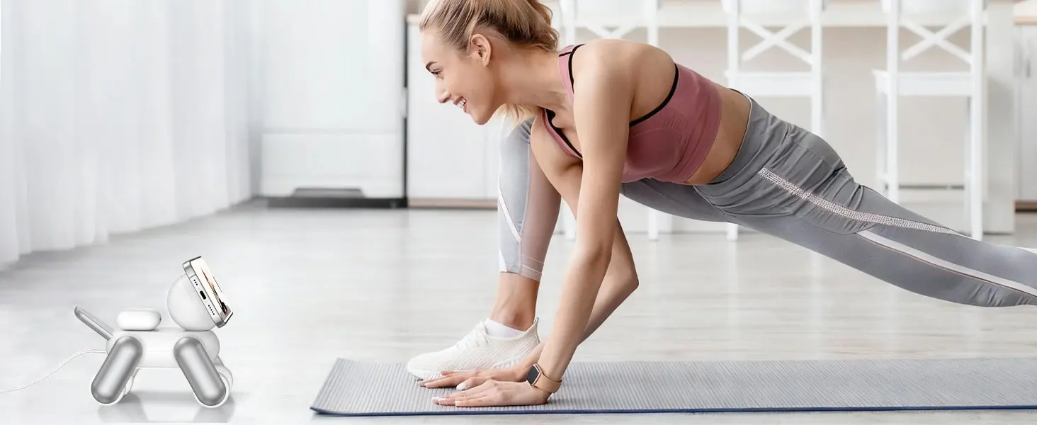 Une femme effectuant une séance de sport et de yoga à la maison sur un tapis, tout en suivant sa vidéo d'entraînement sur un smartphone fixé magnétiquement sur la station MagDog blanche.