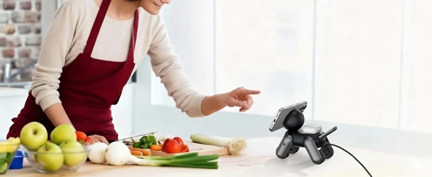 Utilisation en cuisine du support magnétique MagDog noir posé sur un plan de travail pour consulter facilement une recette de cuisine sur son téléphone portable en préparant des légumes.
