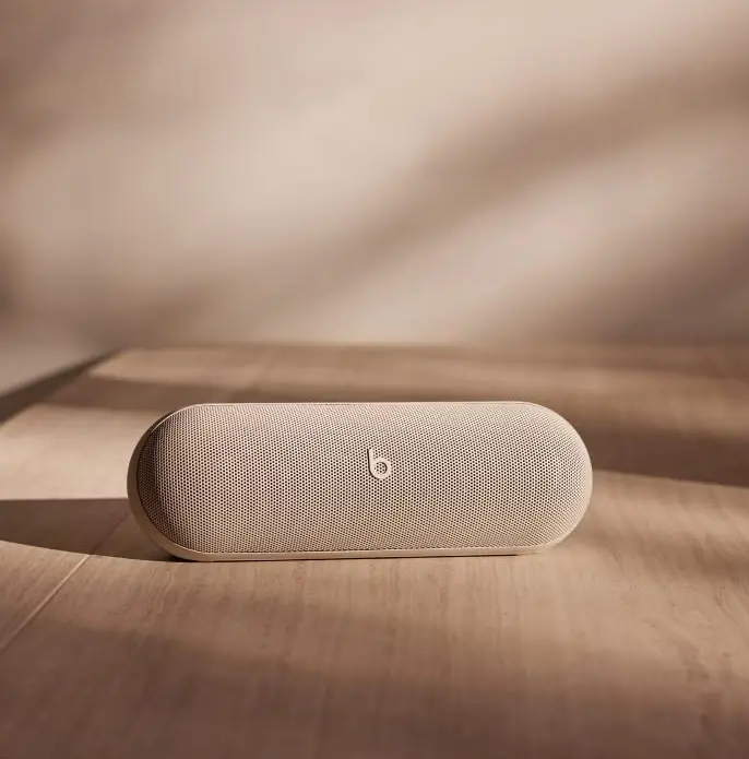 Enceinte Beats Pill Kim Kardashian posée sur un meuble en bois baigné de lumière