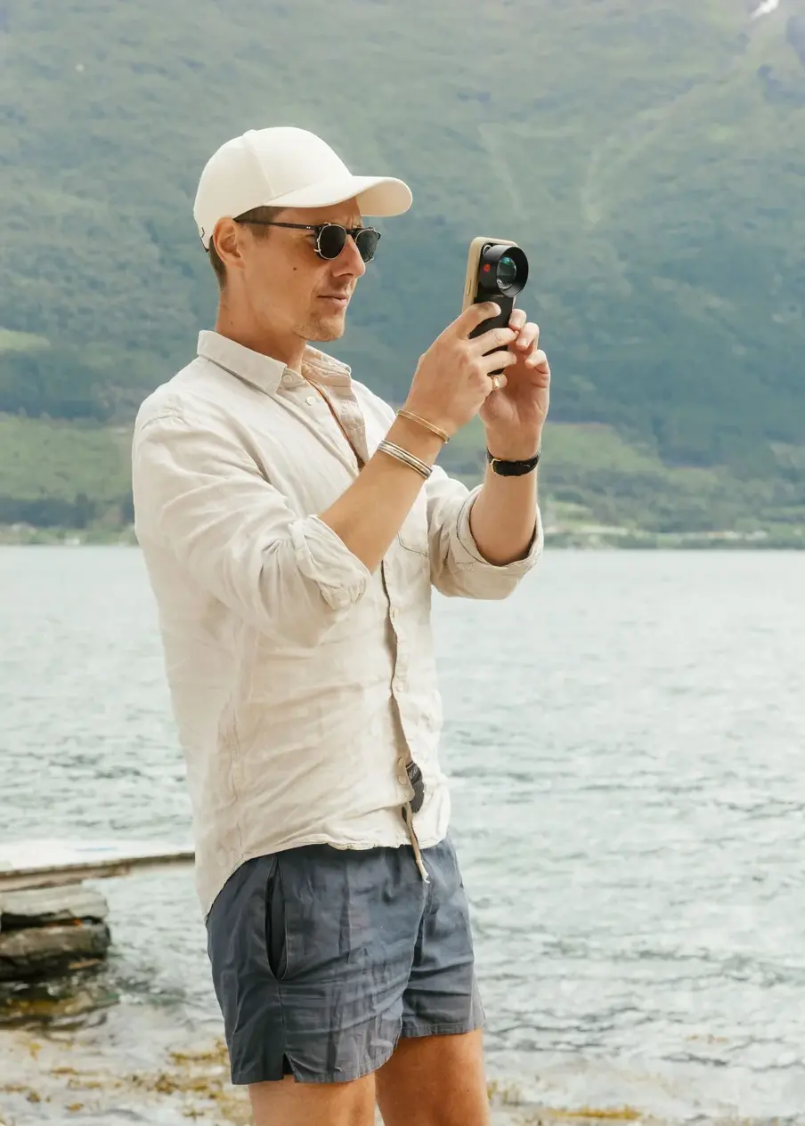 Photographe au bord d'un lac utilisant un smartphone avec le téléobjectif MOMENT Tele 58mm II T-Series