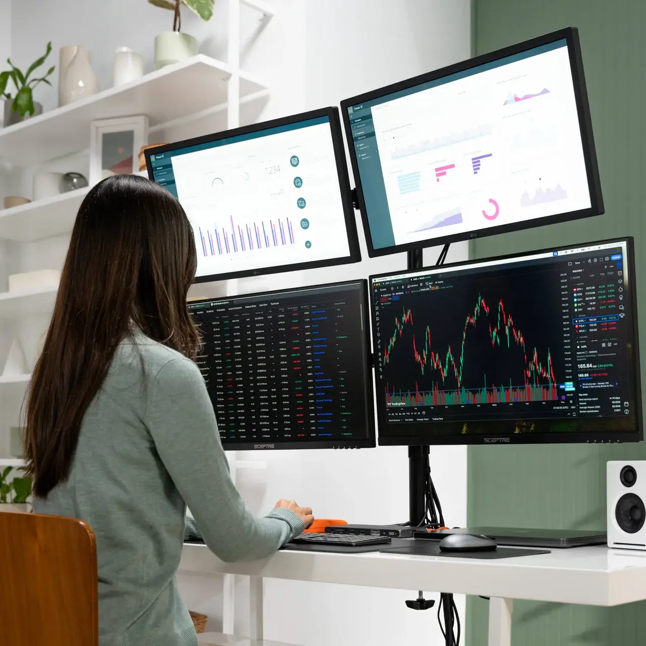 Femme travaillant à son bureau devant une configuration multi-écrans professionnelle avec quatre moniteurs connectés à la station d'accueil Satechi