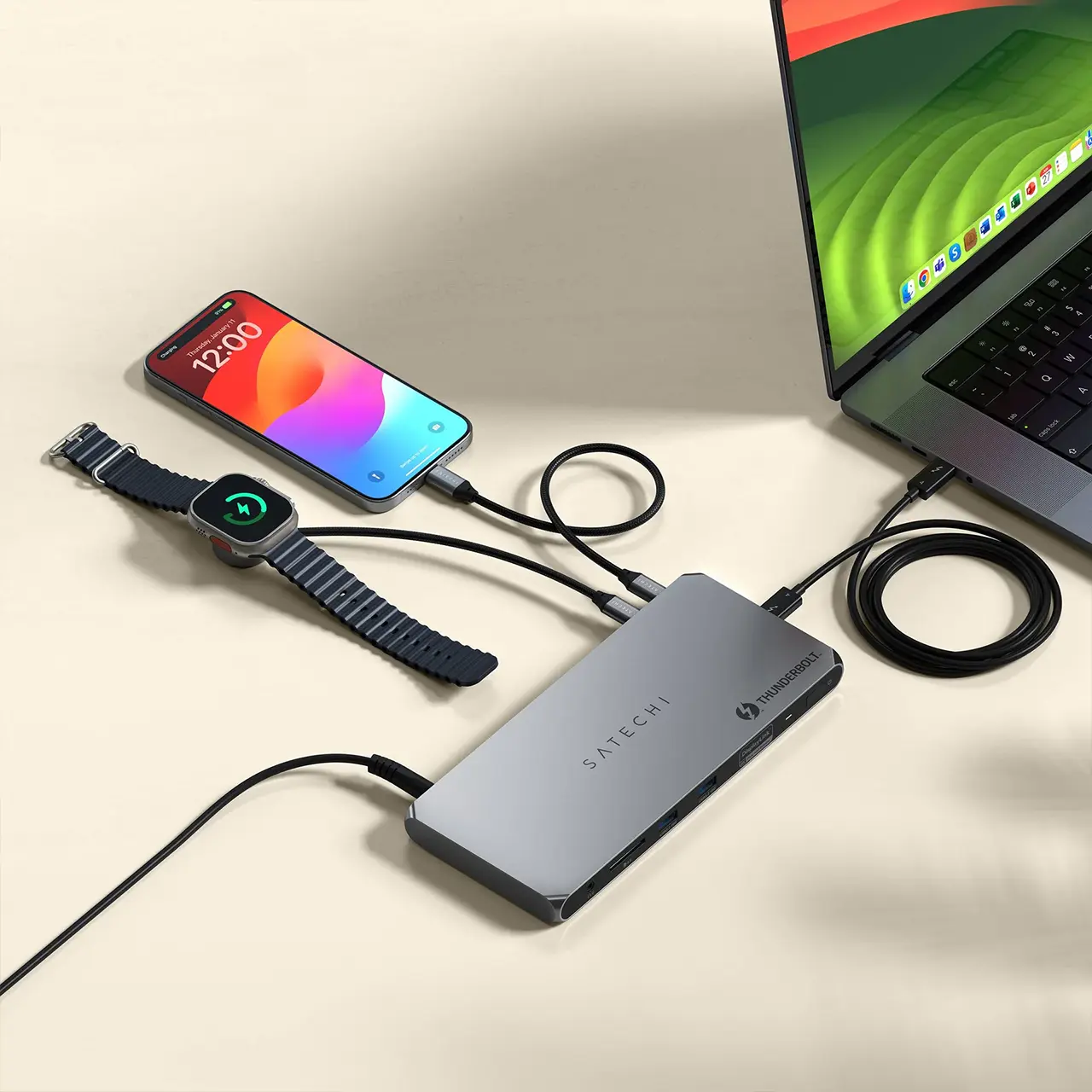 Station d'accueil Satechi Thunderbolt 4 rechargeant simultanément un MacBook Pro, un smartphone et une montre connectée sur un bureau
