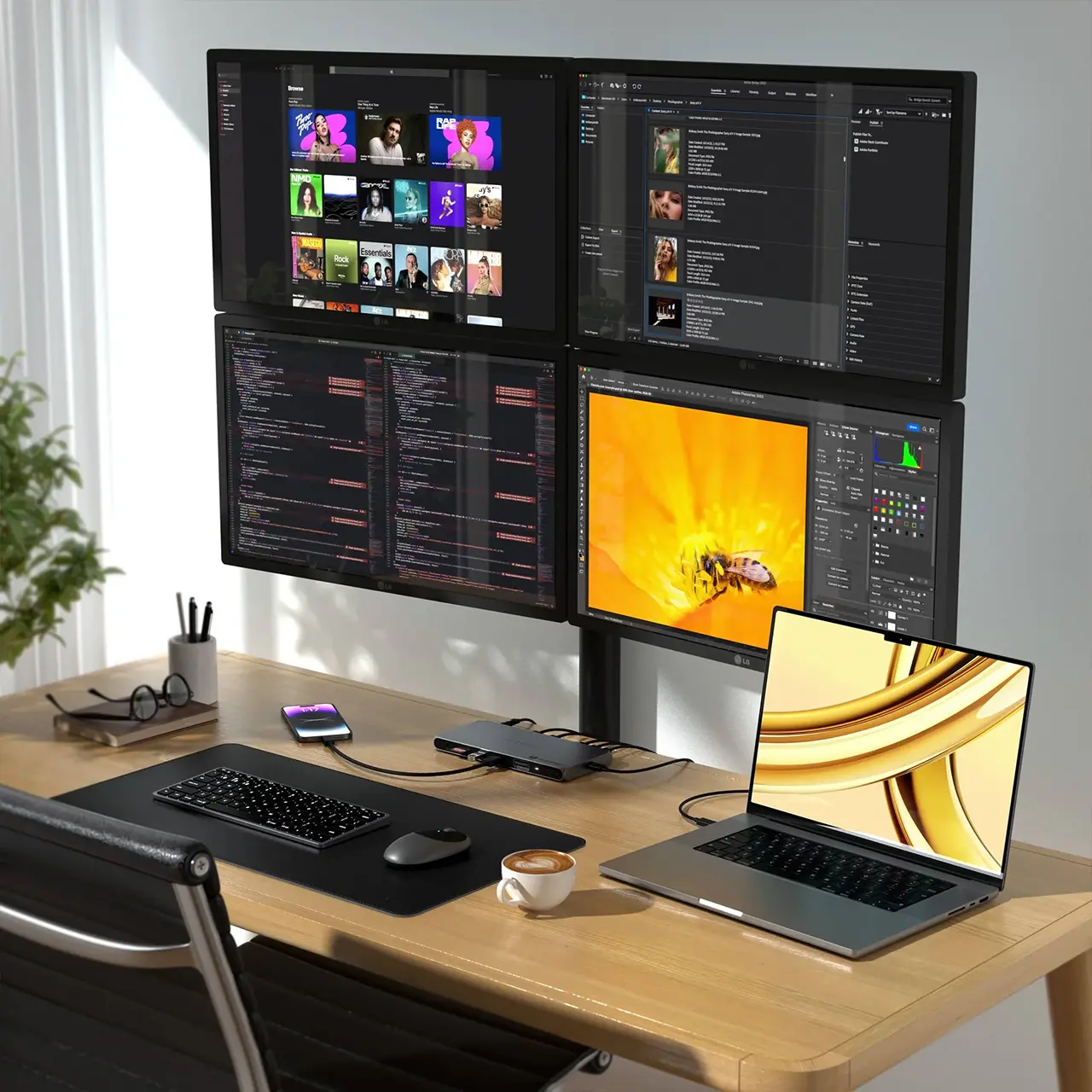 Bureau minimaliste et épuré avec la station d'accueil Satechi connectée à un MacBook Pro et une configuration à quatre écrans
