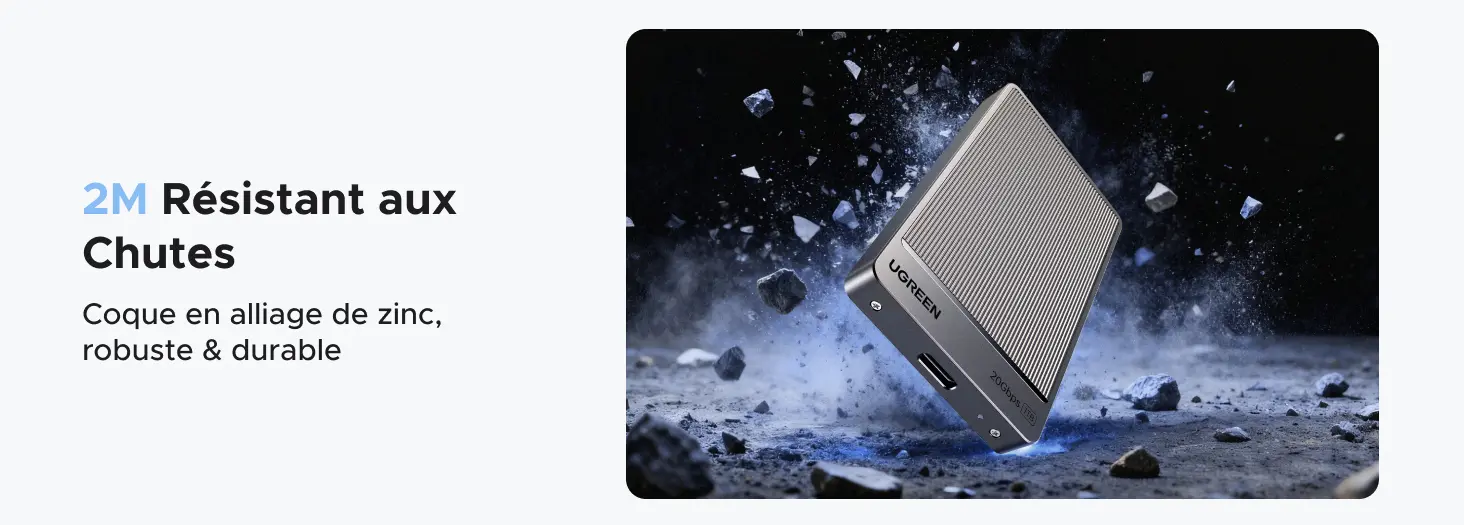 Visuel publicitaire démontrant la résistance aux chocs du SSD externe portable UGREEN 1TB. L'image affiche le texte 2M Résistant aux Chutes et Coque en alliage de zinc, robuste & durable, illustrant le disque dur métallique subissant un impact au sol parmi des éclats de roche pour prouver sa solidité en déplacement.