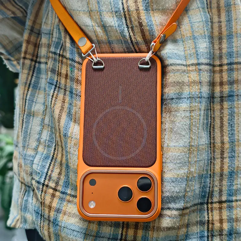 Coque SkinFeel MagSafe orange pour iPhone 17 Pro Max portée en bandoulière – coque textile avec anneaux intégrés